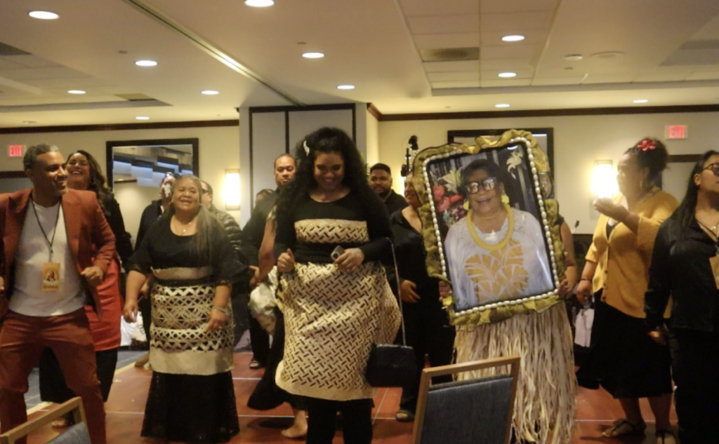 Community members dance with Mama Dee’s picture at the reception.